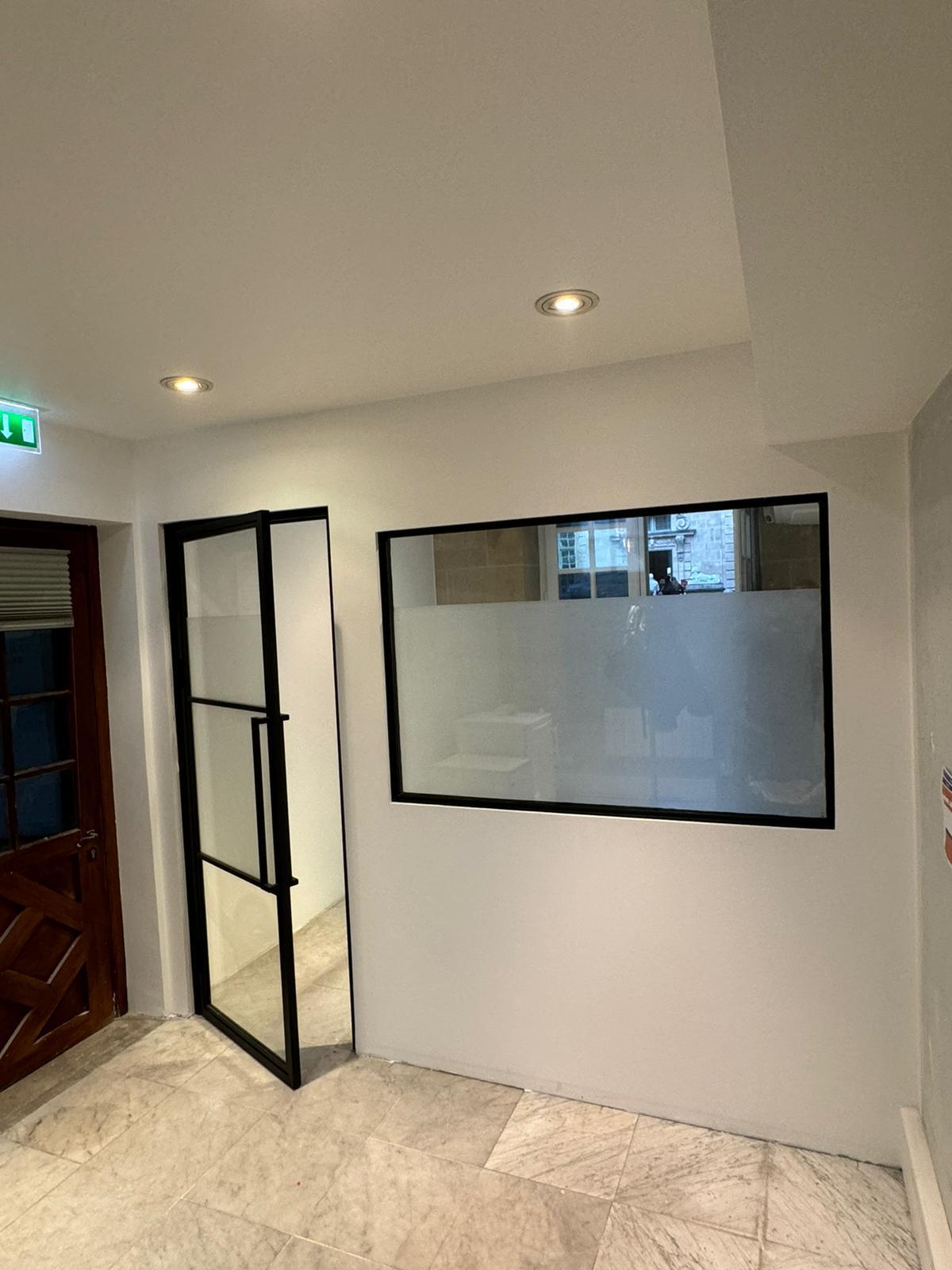 Verrière et cloison à menuiserie phonique séparant deux bureaux à Paris, réalisée par L'Artisan Rénov